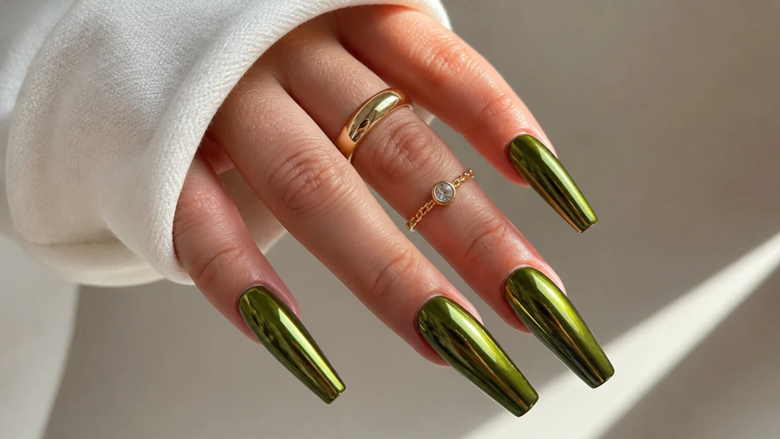 Bold olive green chrome nails on a long coffin shape catching light