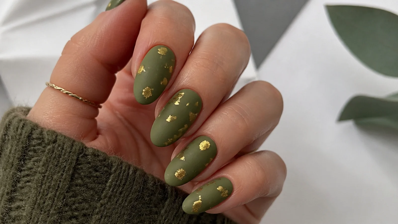 Matte olive green nails with scattered gold leaf flakes