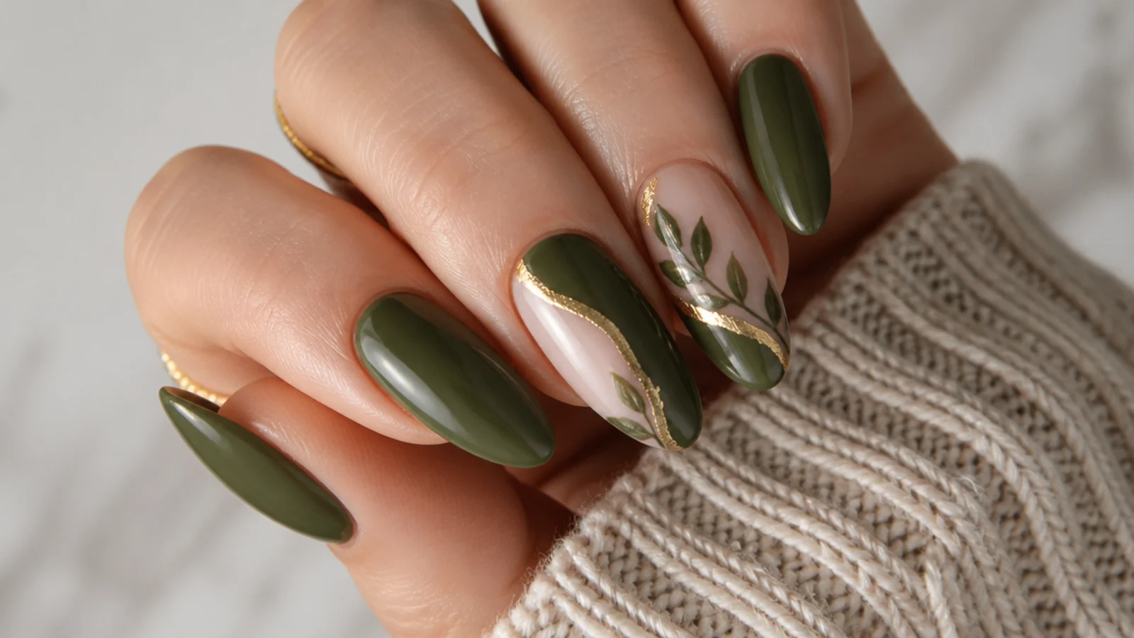 Warm olive green fall nails in an almond shape with gold accents