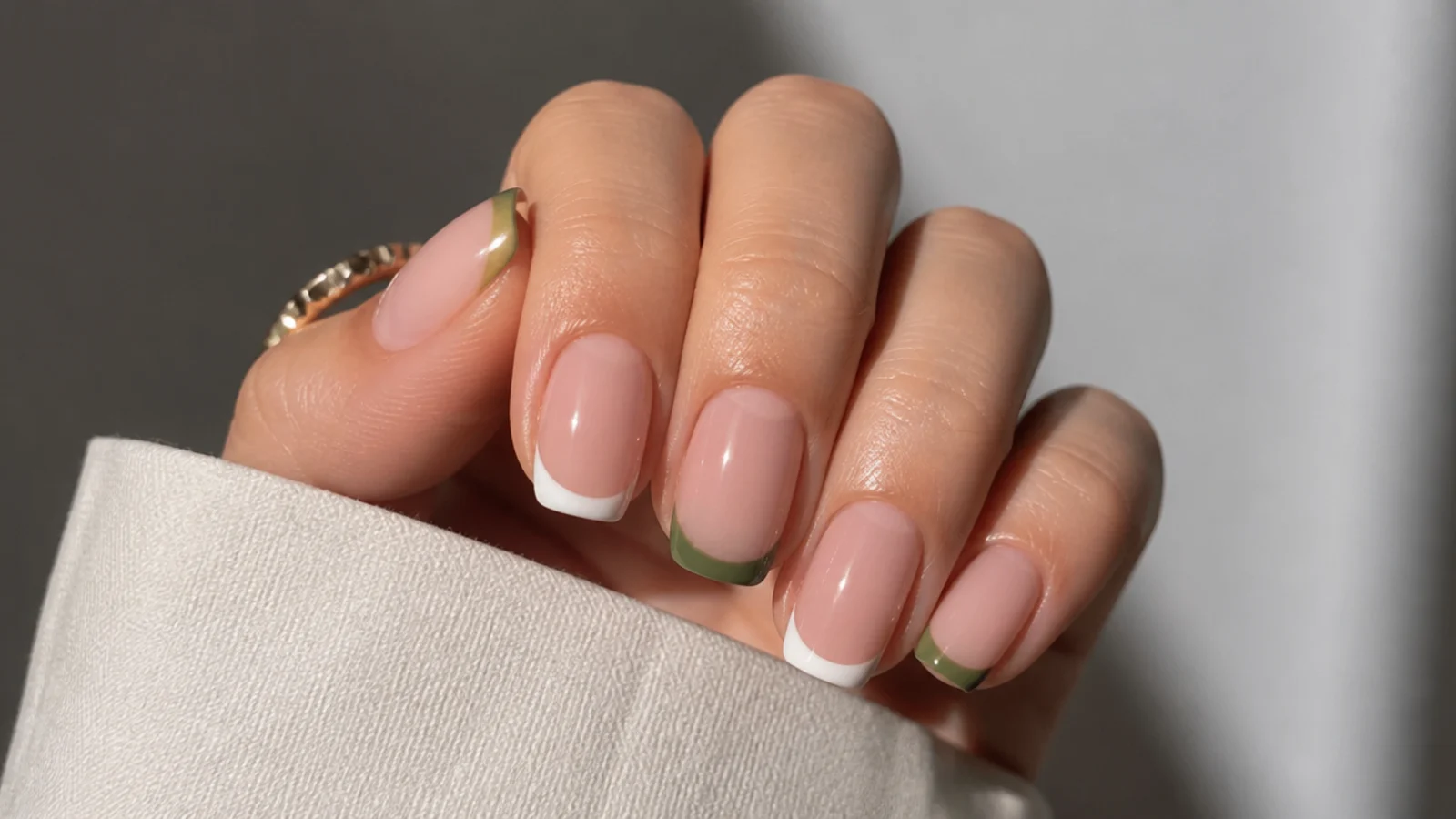 French tips alternating olive green and white across nude nails