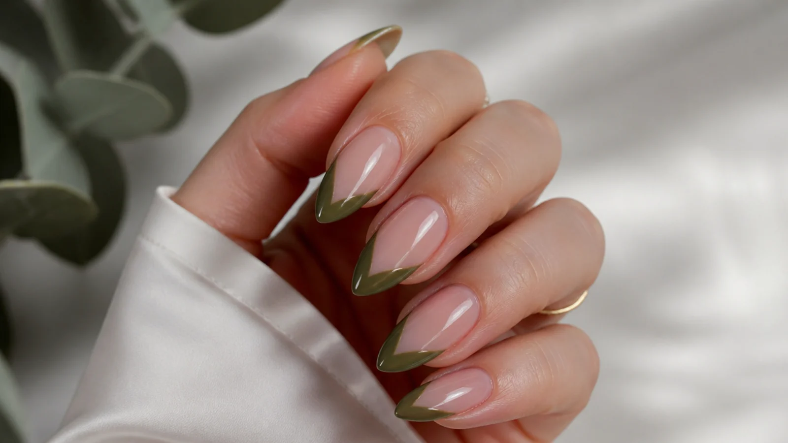 Olive green chevron V-shaped french tips over nude almond nails