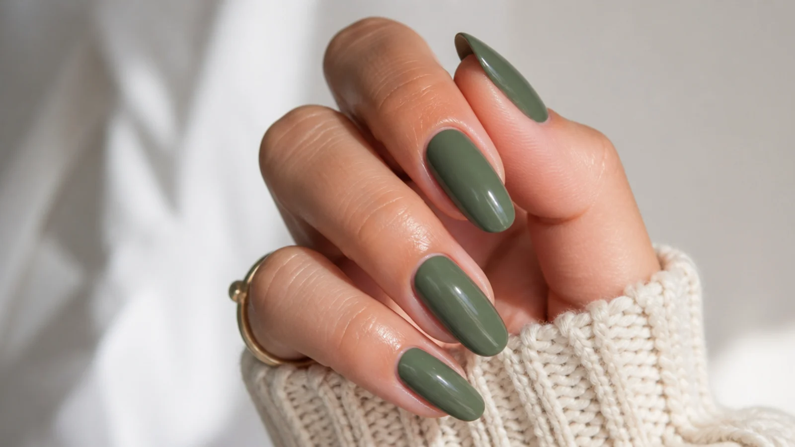 Solid muted olive green glossy nails on an almond shape