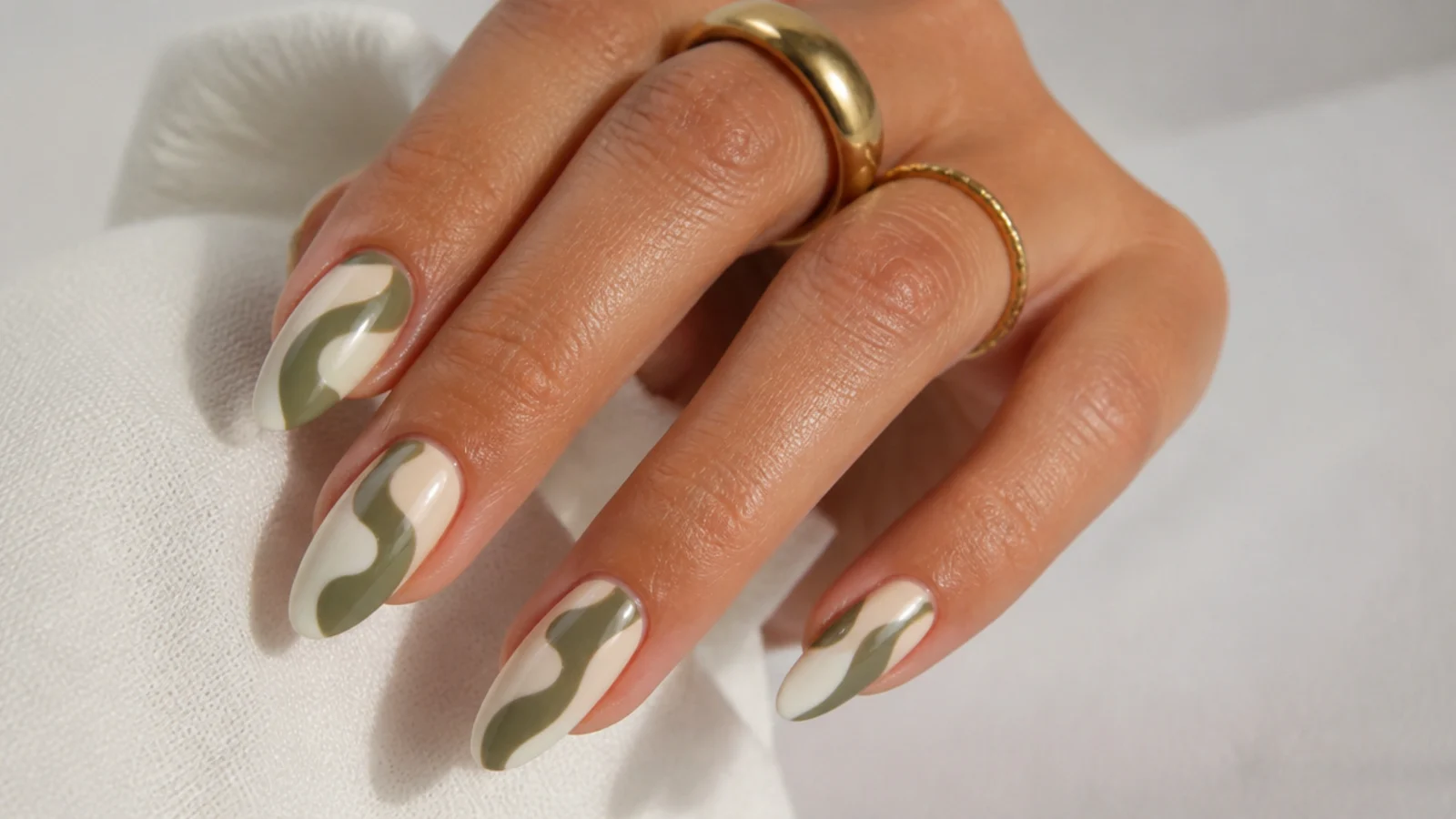Olive green and cream swirl nails in a retro wave pattern