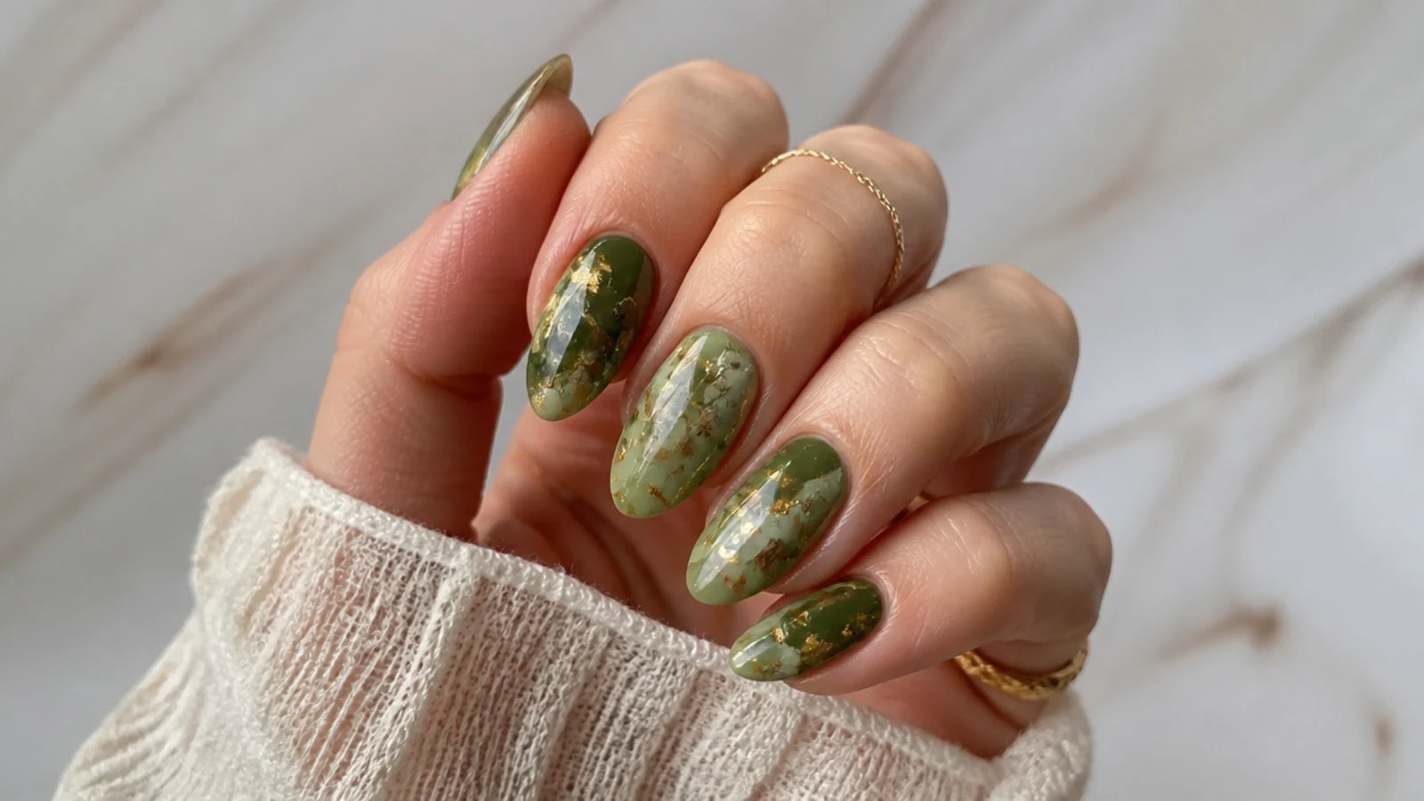 Almond nails in olive green with torn gold foil flakes and marble veins