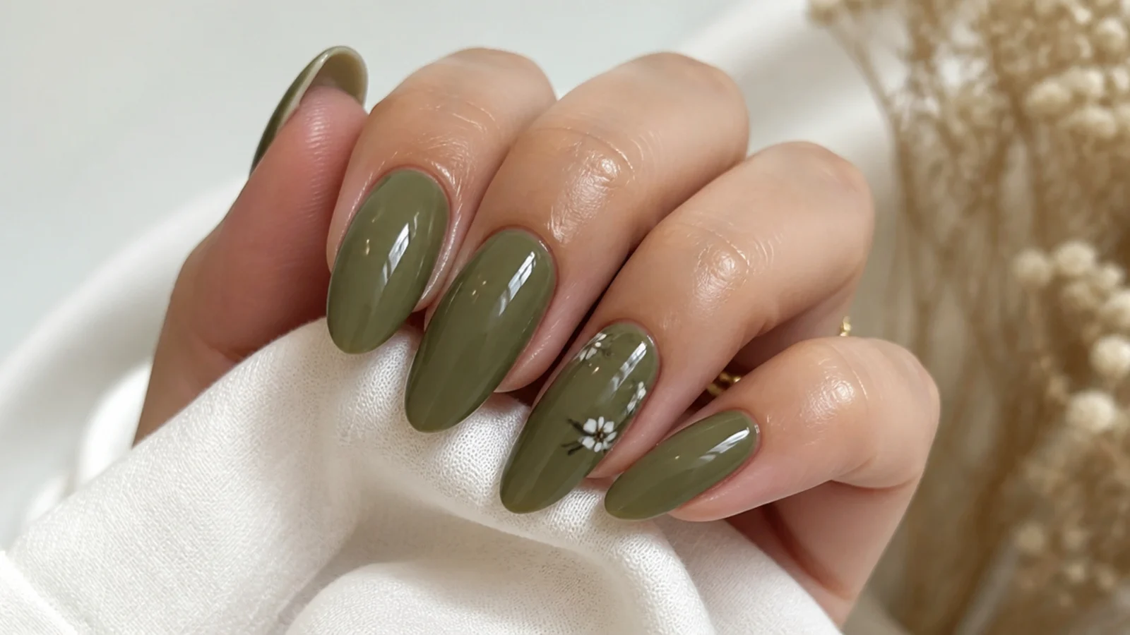 A well-sealed glossy olive green manicure with cuticle oil