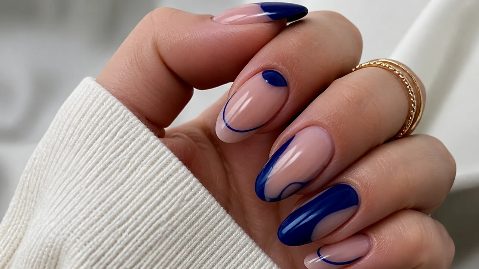 Nude royal blue nails with bare negative-space cutouts and blue shapes