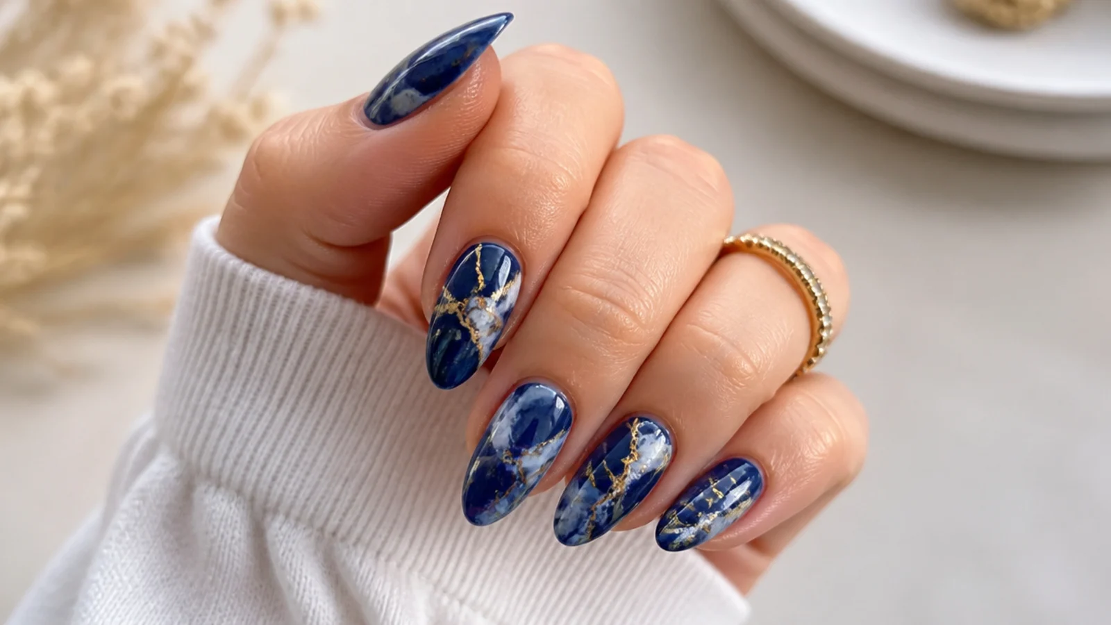 Royal blue nails with white marble veining and thin gold foil lines