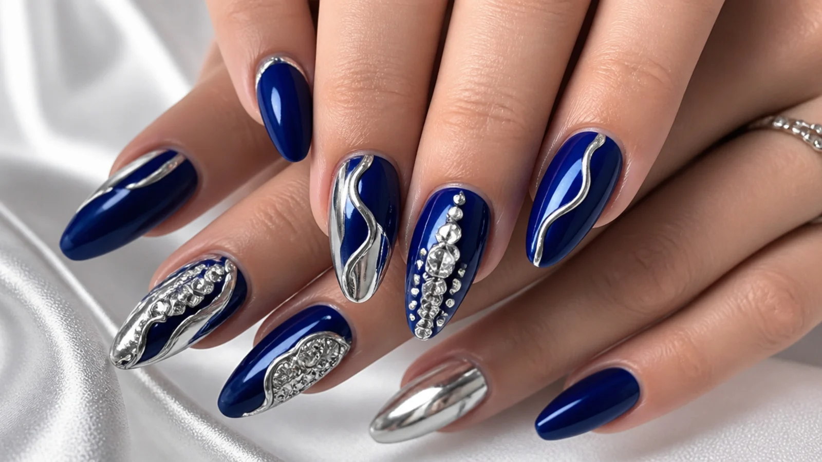 Royal blue almond nails with silver rhinestones and chrome for prom