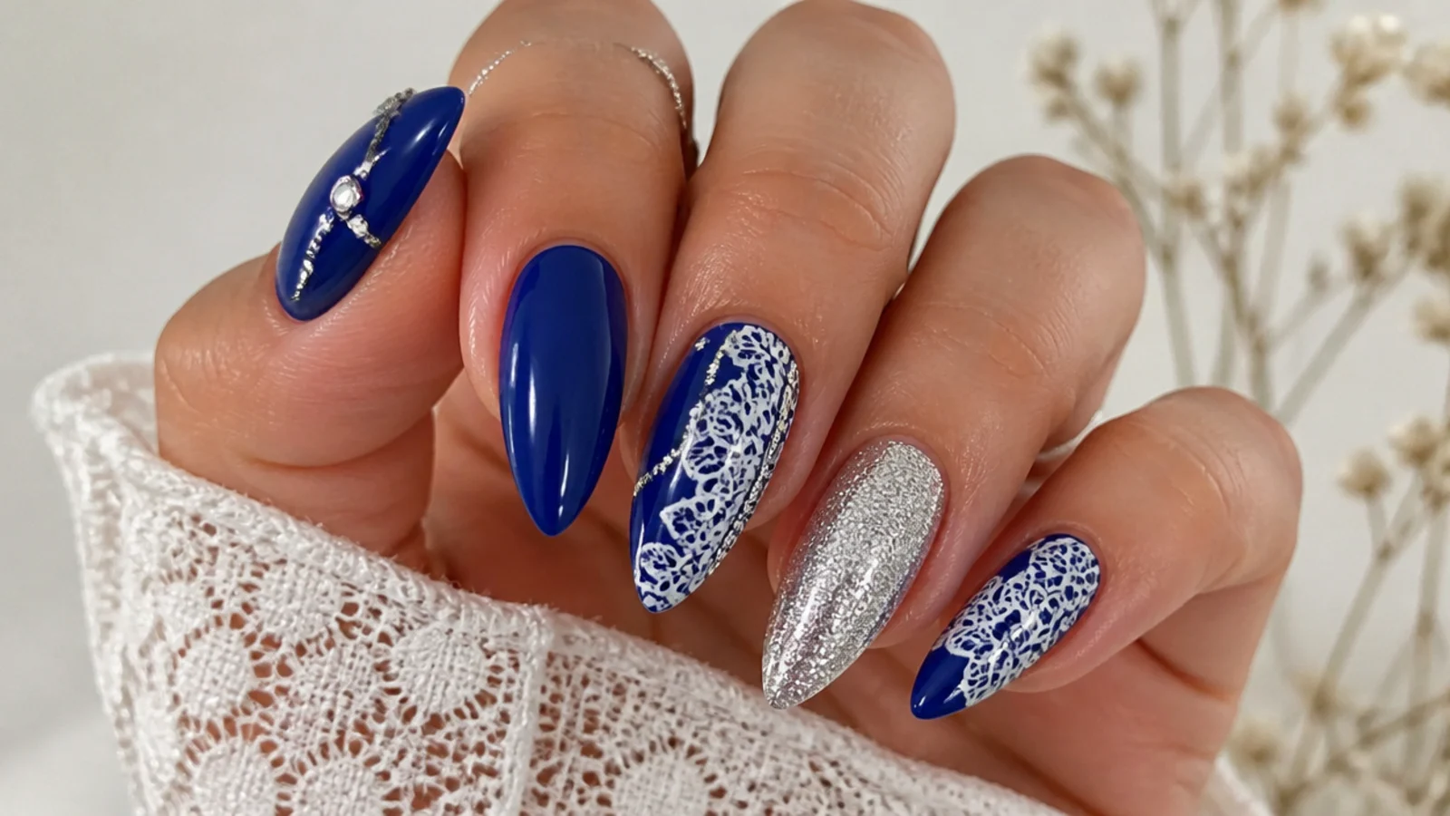 Royal blue nails with silver and white lace-style accents for a quinceanera