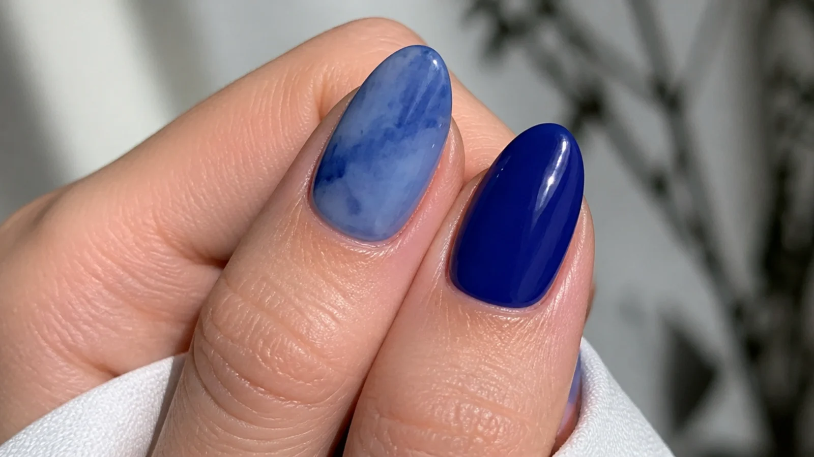 A streaky patchy blue nail next to a smooth deep cobalt one for comparison