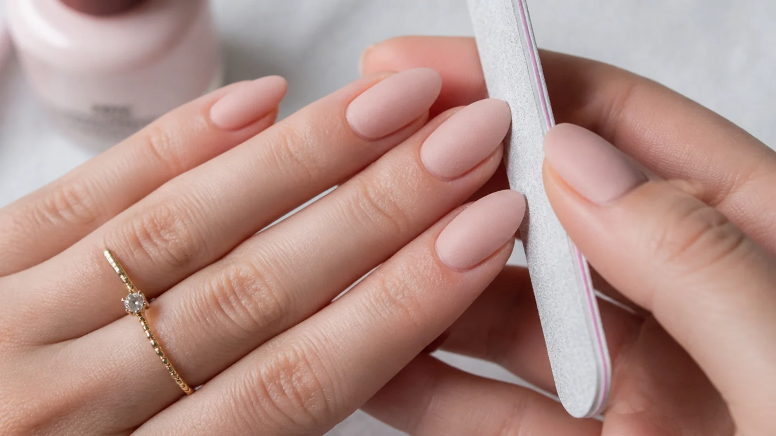Nails being filed and buffed to a matte finish in preparation for gel