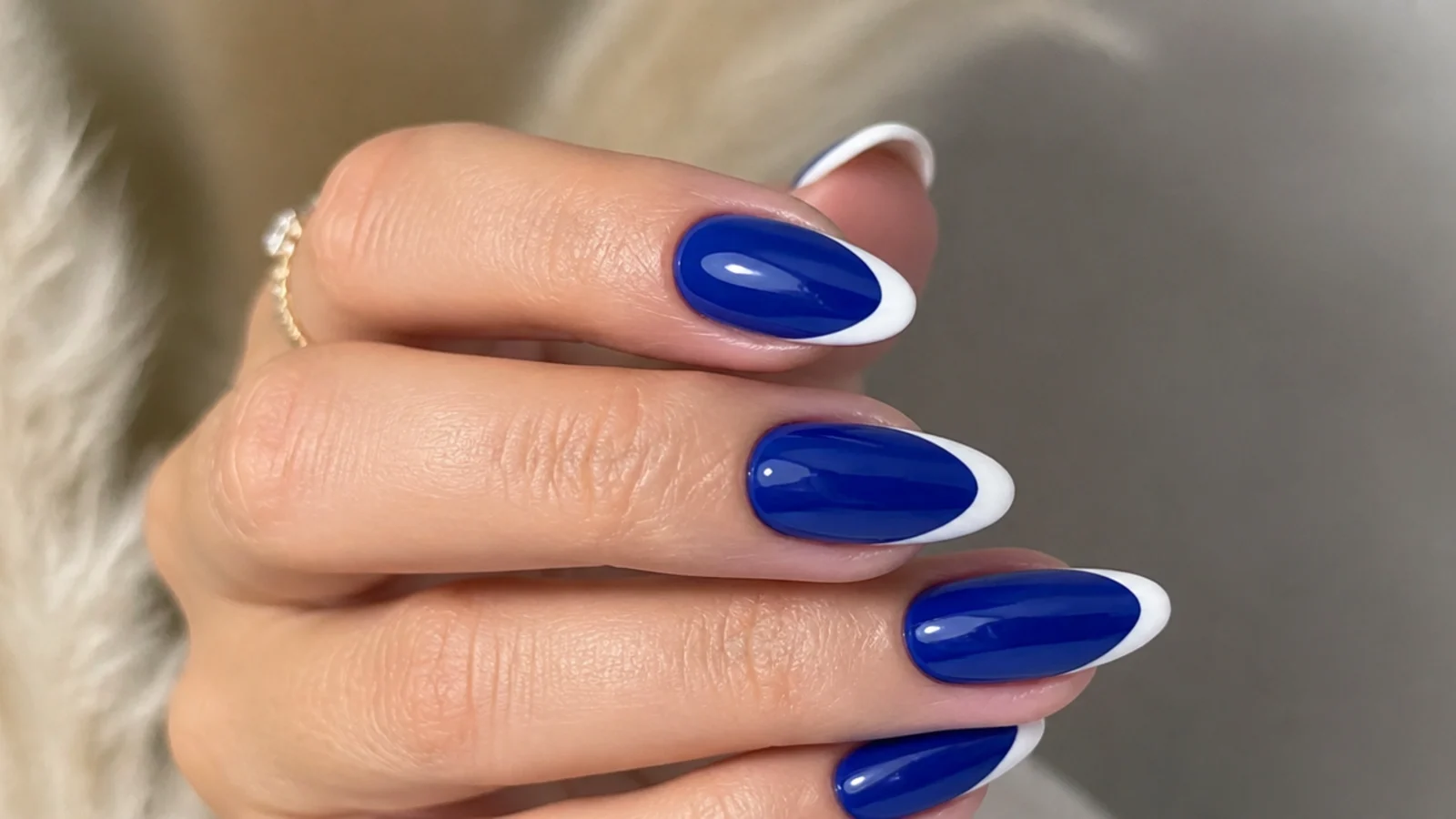 Royal blue acrylic nails with crisp white french tips on almond nails