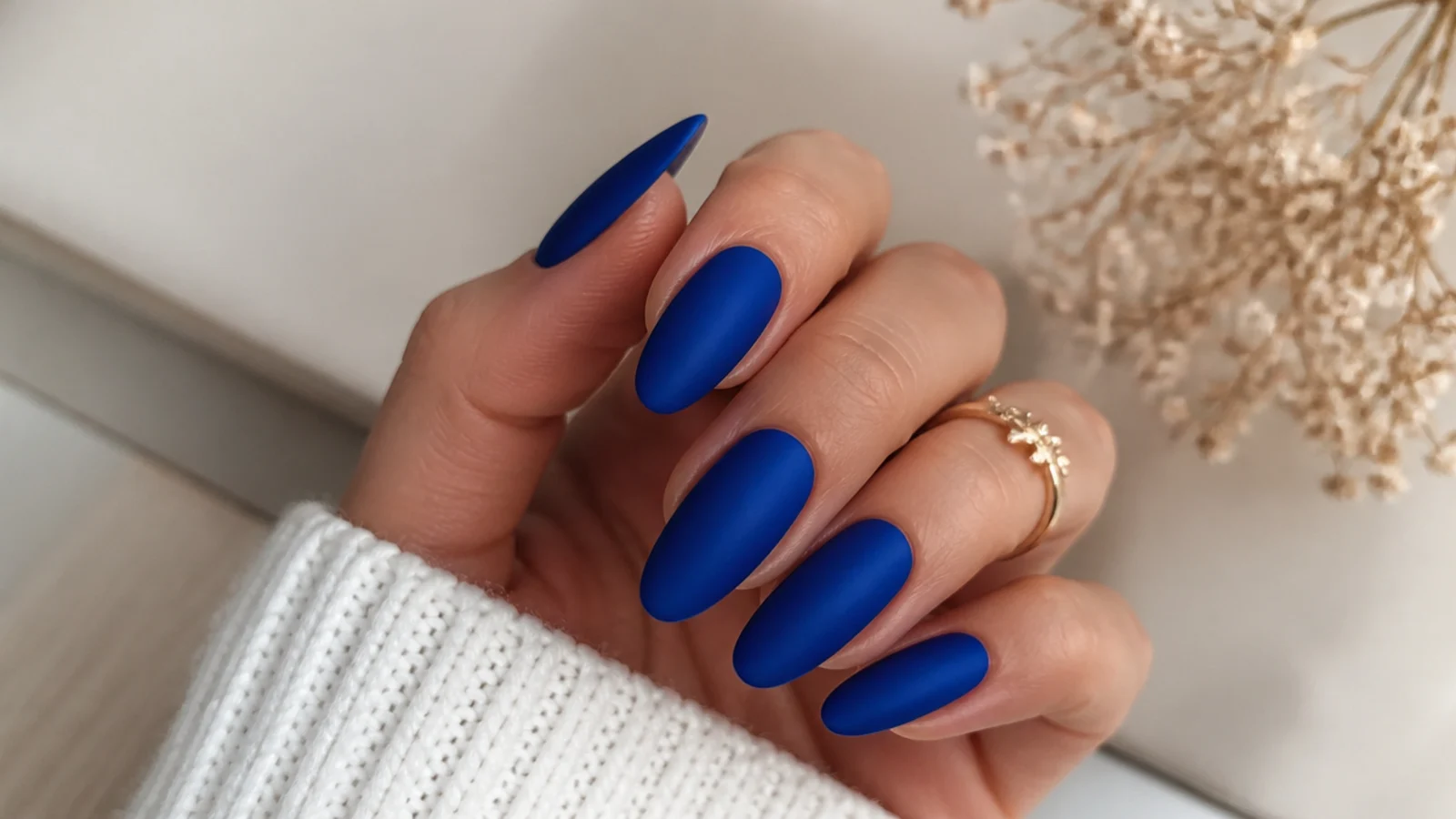 Matte royal blue acrylic nails with a velvety flat finish on almond nails