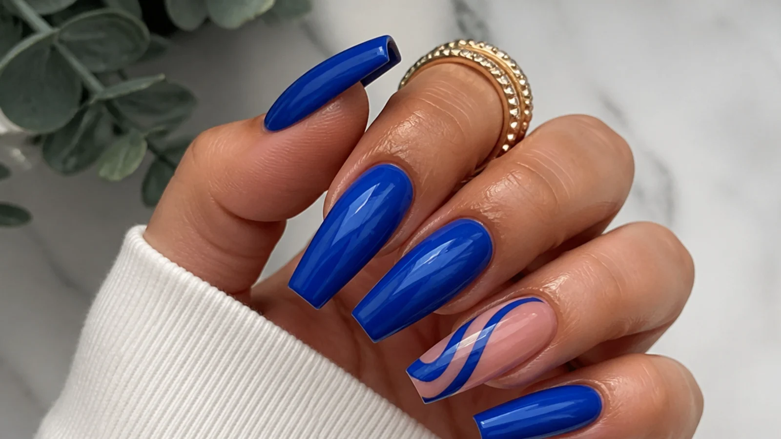 Medium royal blue acrylic nails in a tapered coffin shape on medium skin