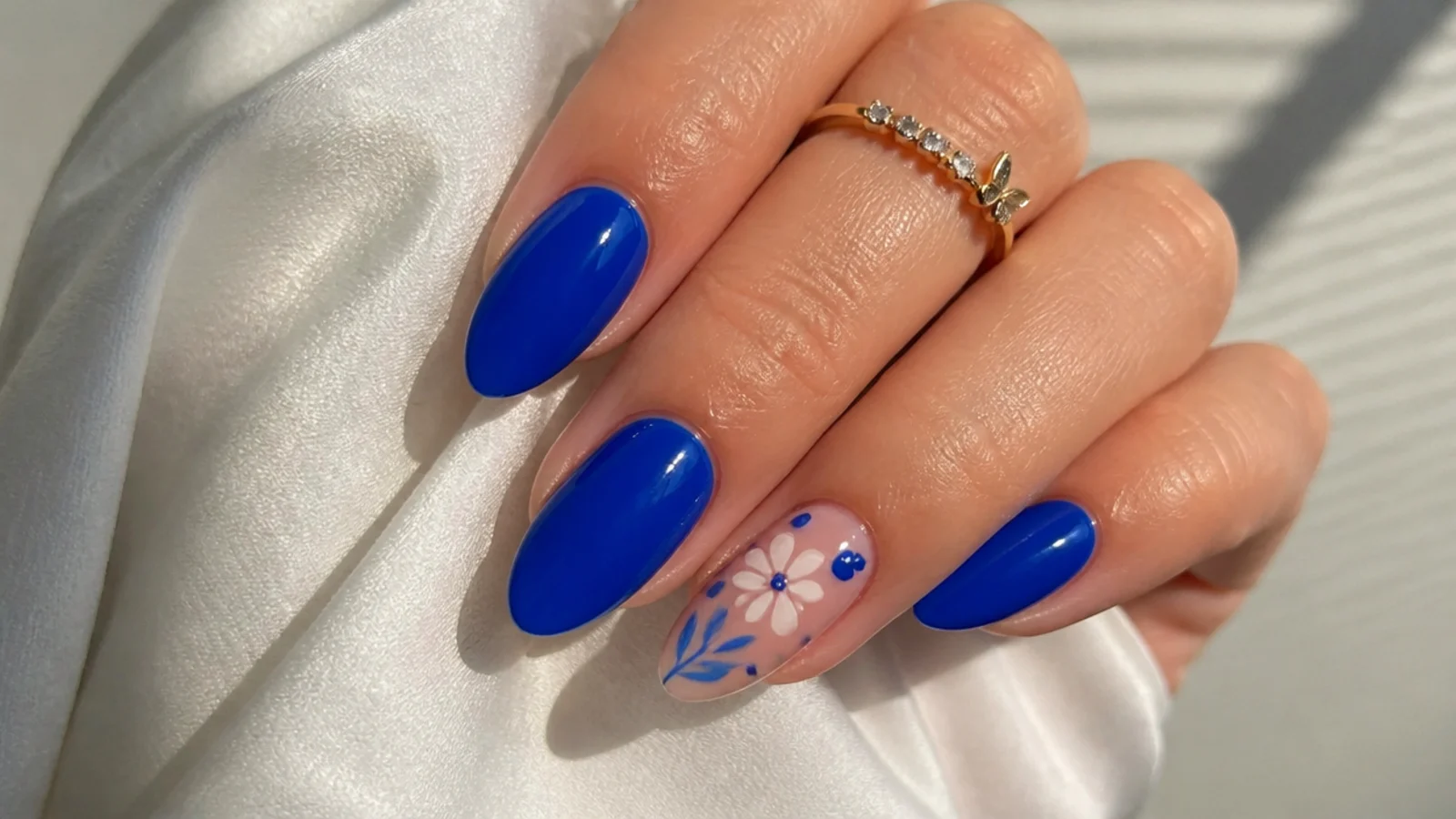 Royal blue acrylic nails in a soft almond shape on short fingers