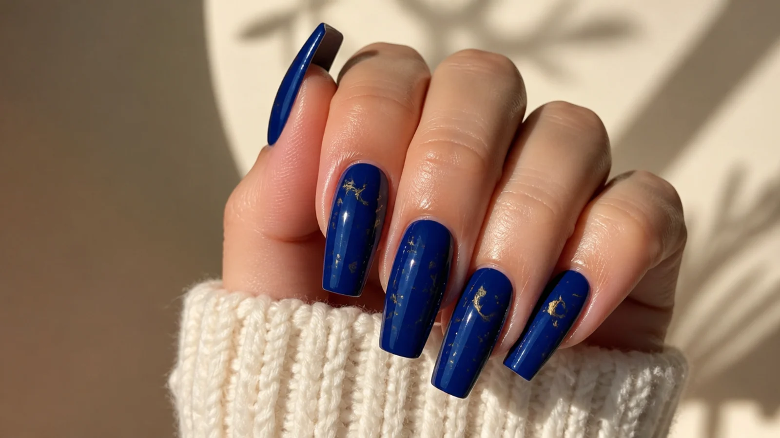 Royal blue acrylic nails with tiny gold star and moon accents on coffin nails