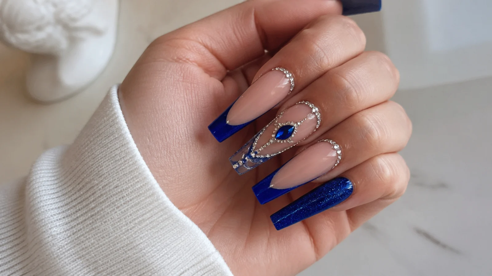 Royal blue acrylic nails with silver crystals and french detailing for a quince on coffin nails