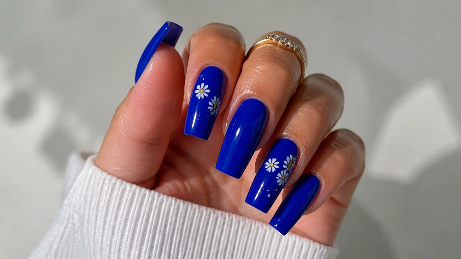 A well-sealed royal blue acrylic manicure with cuticle oil for longevity
