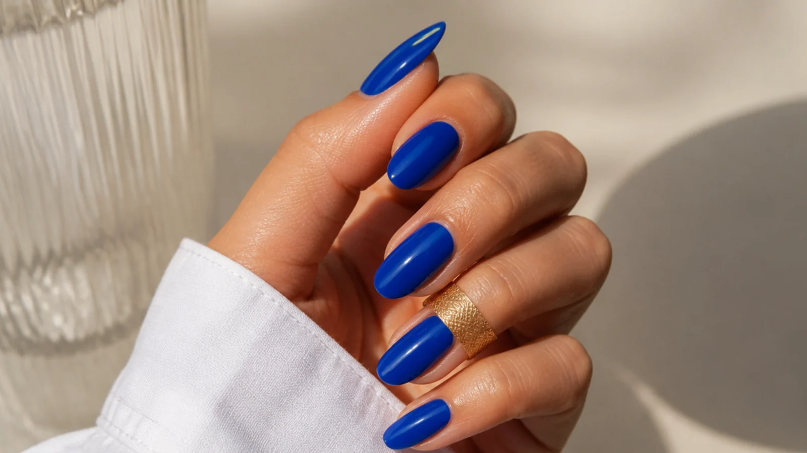 High-gloss true royal blue almond nails on medium-toned hands