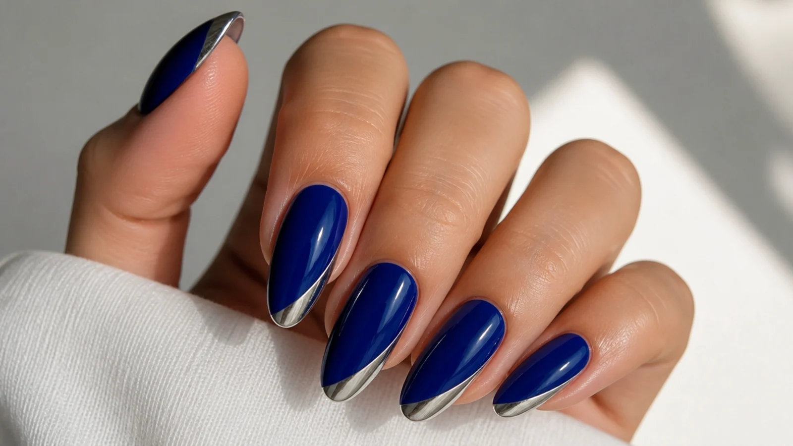 Royal blue almond nails with cool silver chrome accent tips