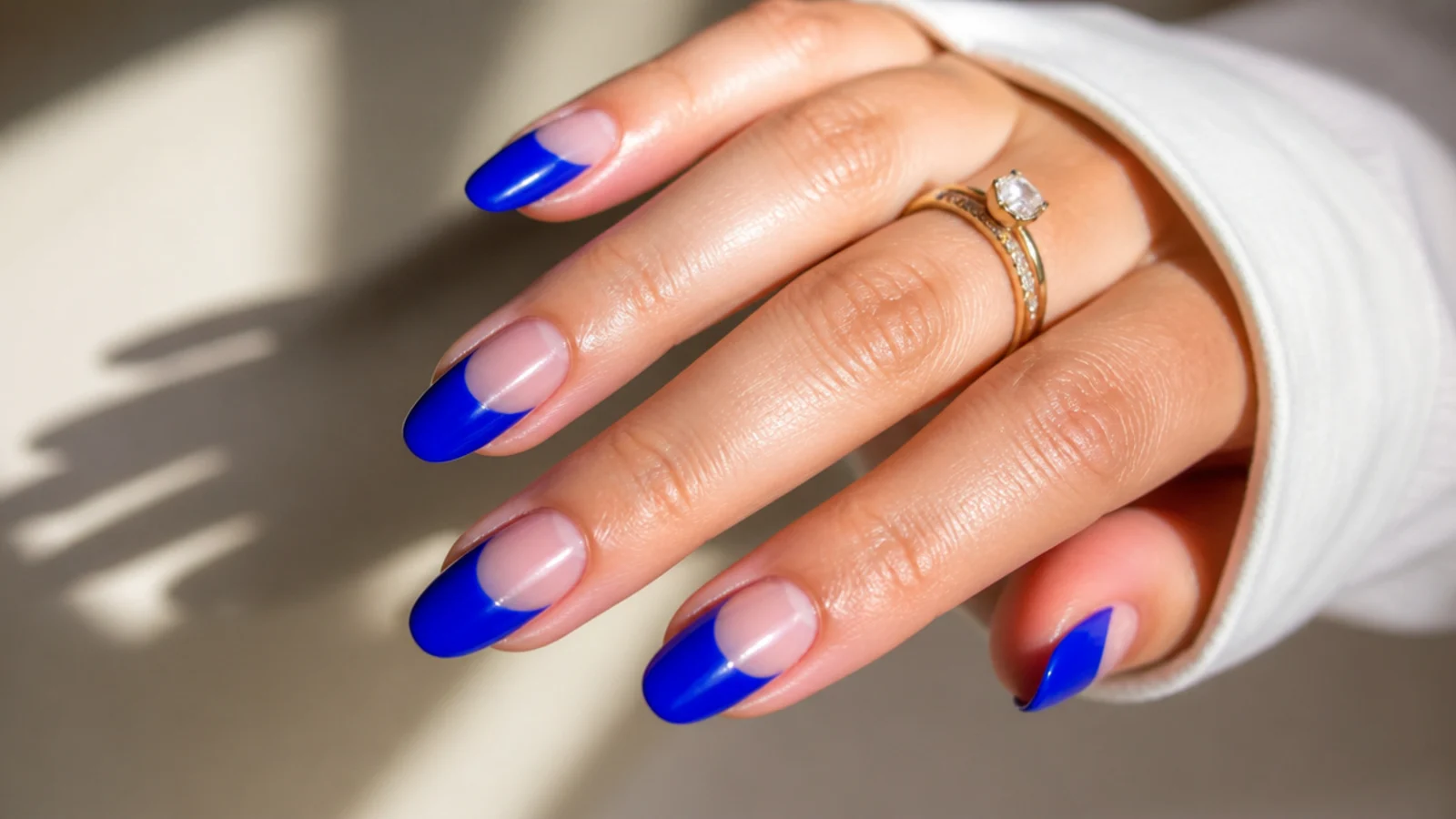 Royal blue almond nails with bare negative space along the cuticle
