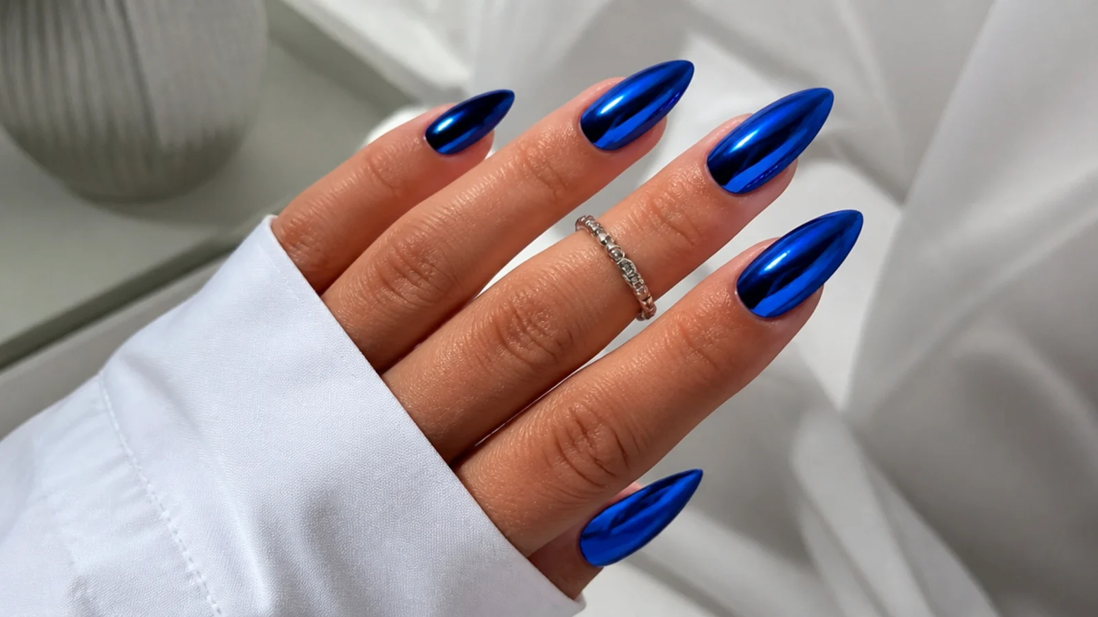 Royal blue almond nails with a full blue metallic chrome mirror finish