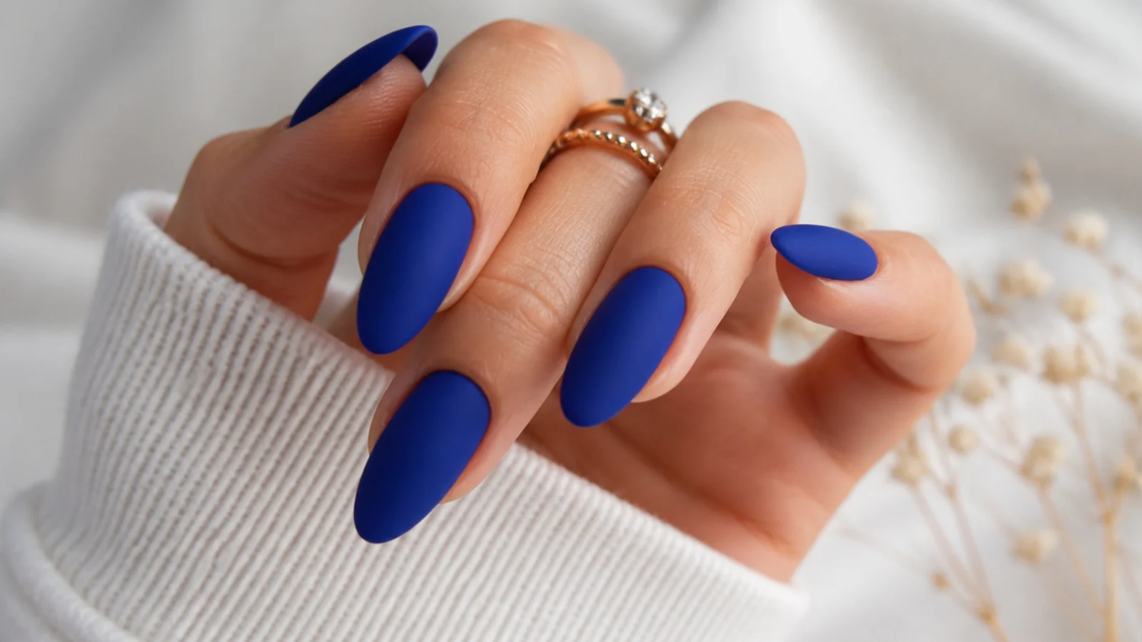 Matte royal blue almond nails with a soft velvet finish
