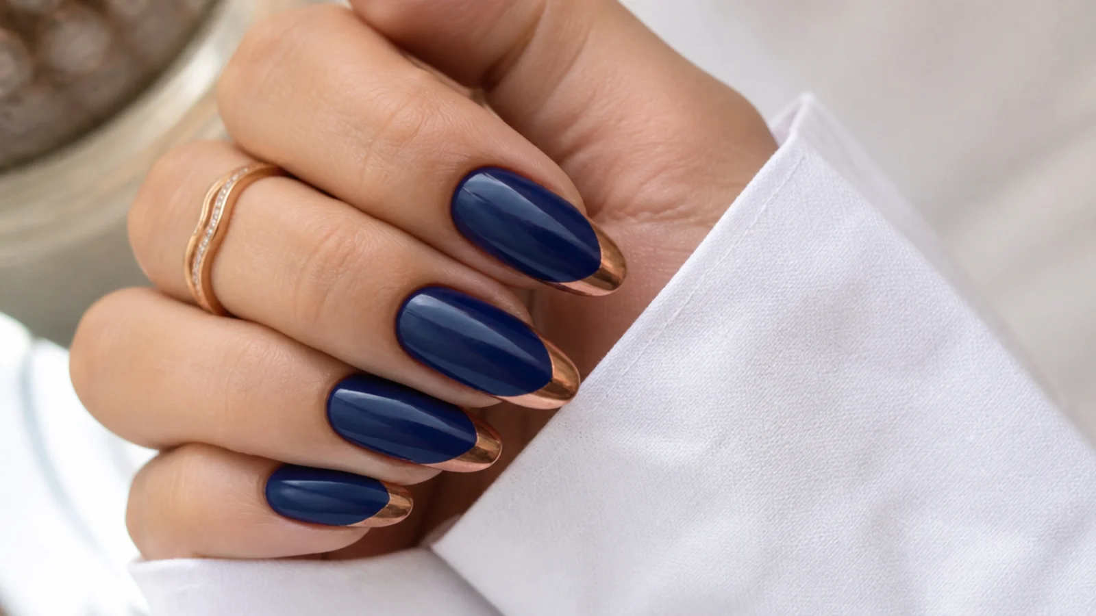 Royal blue almond nails with warm rose gold chrome accent tips