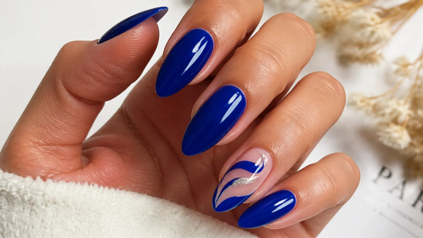 Glossy royal blue almond nails on medium-toned hands