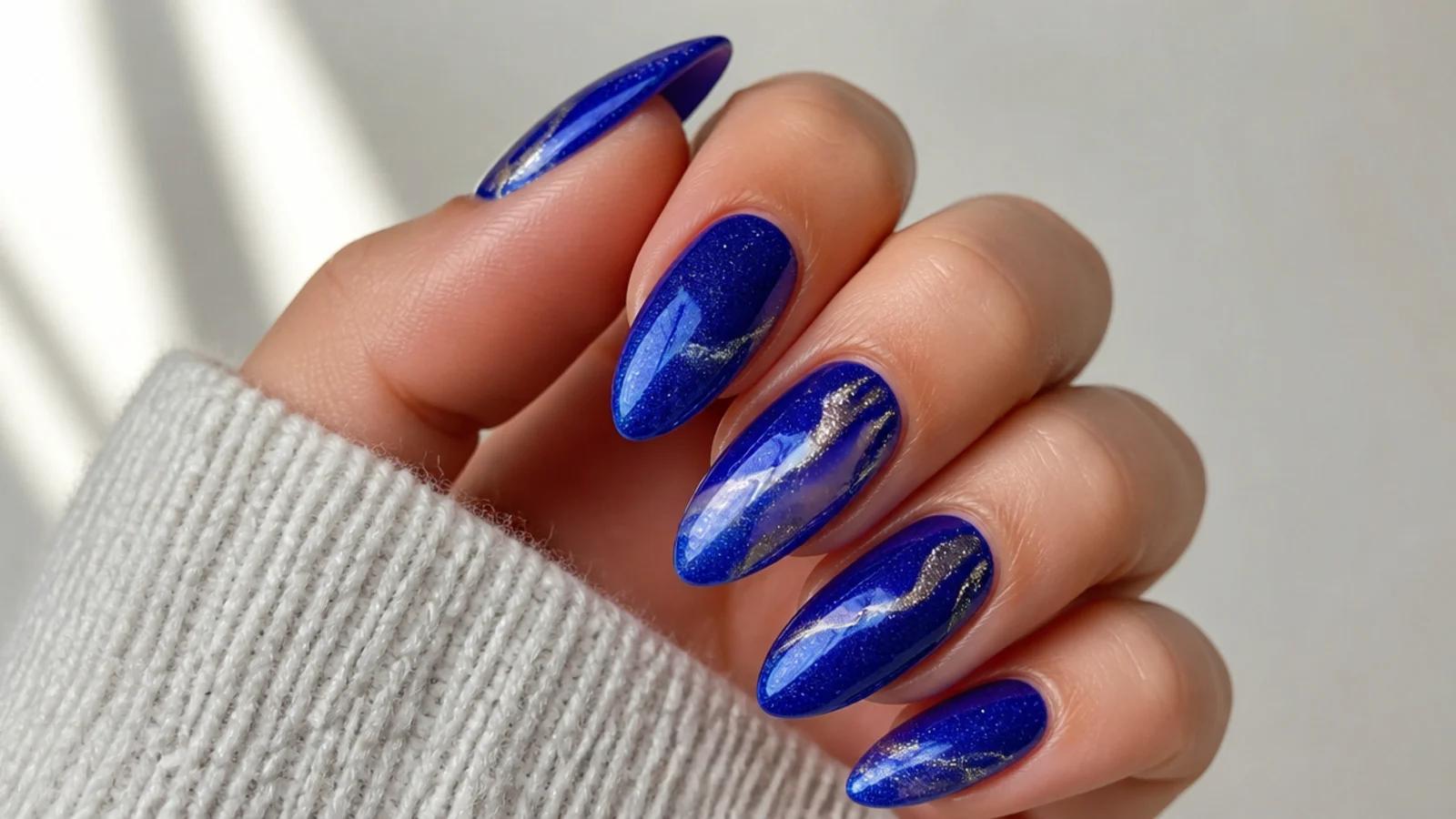 Royal blue almond nails styled for prom, a wedding and everyday wear