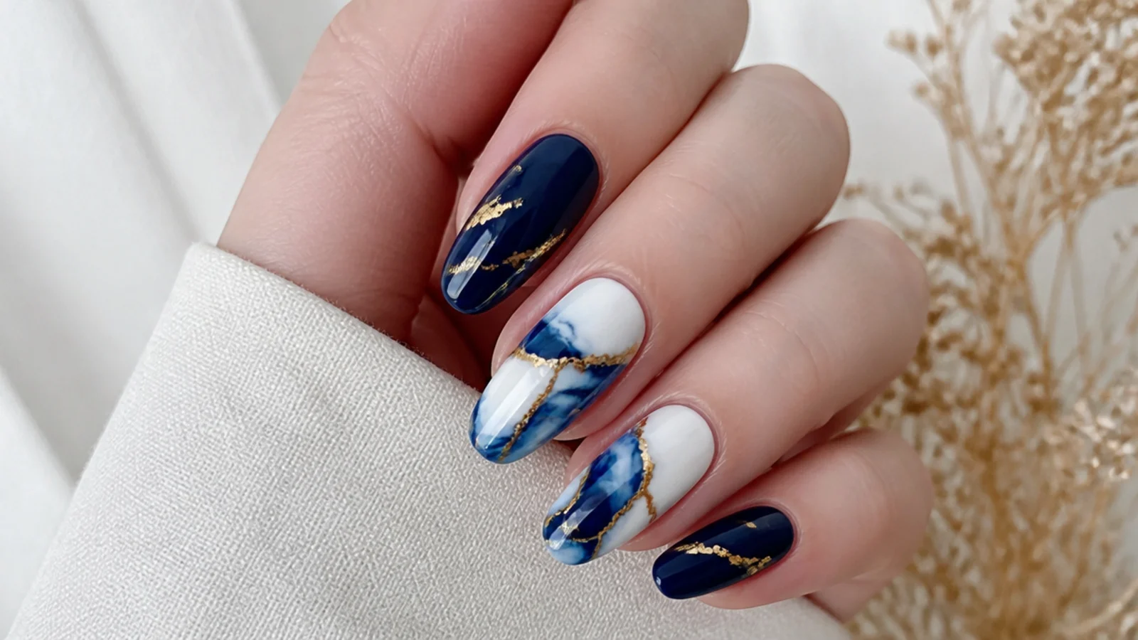 Royal blue and white marble nails threaded with gold leaf veins