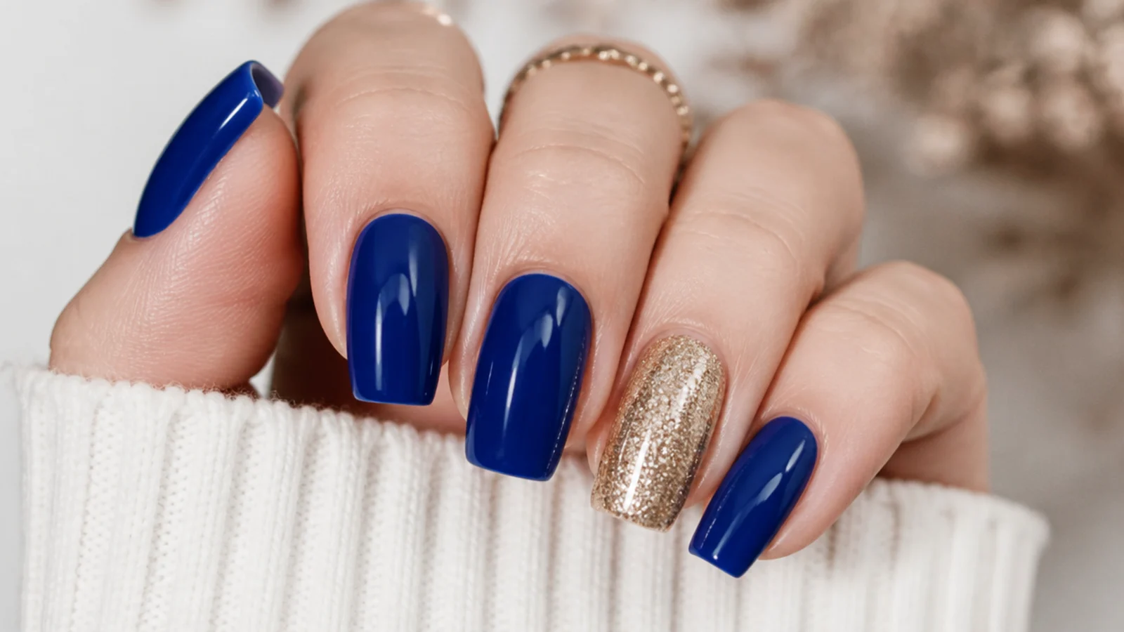 Four royal blue nails with one full gold glitter accent nail