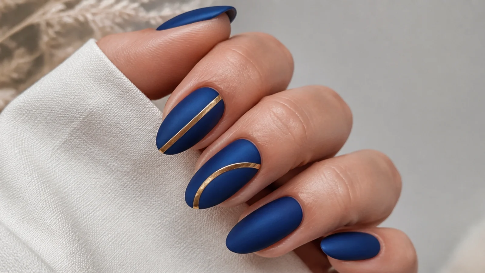Matte royal blue nails with glossy gold accents for contrast