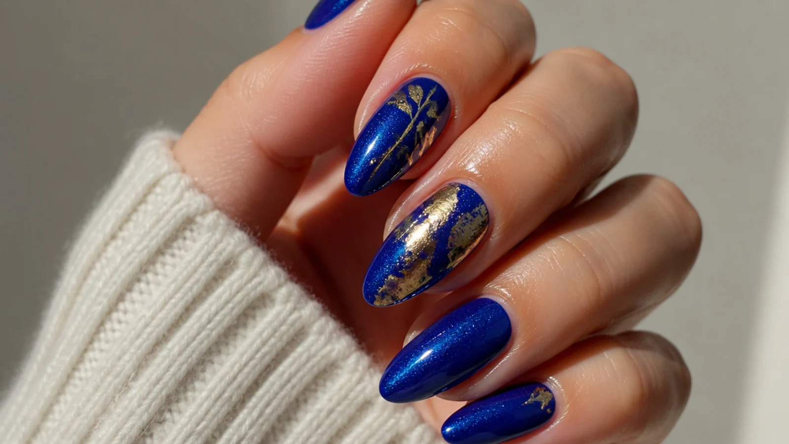 A well-sealed royal blue and gold gel manicure with cuticle oil
