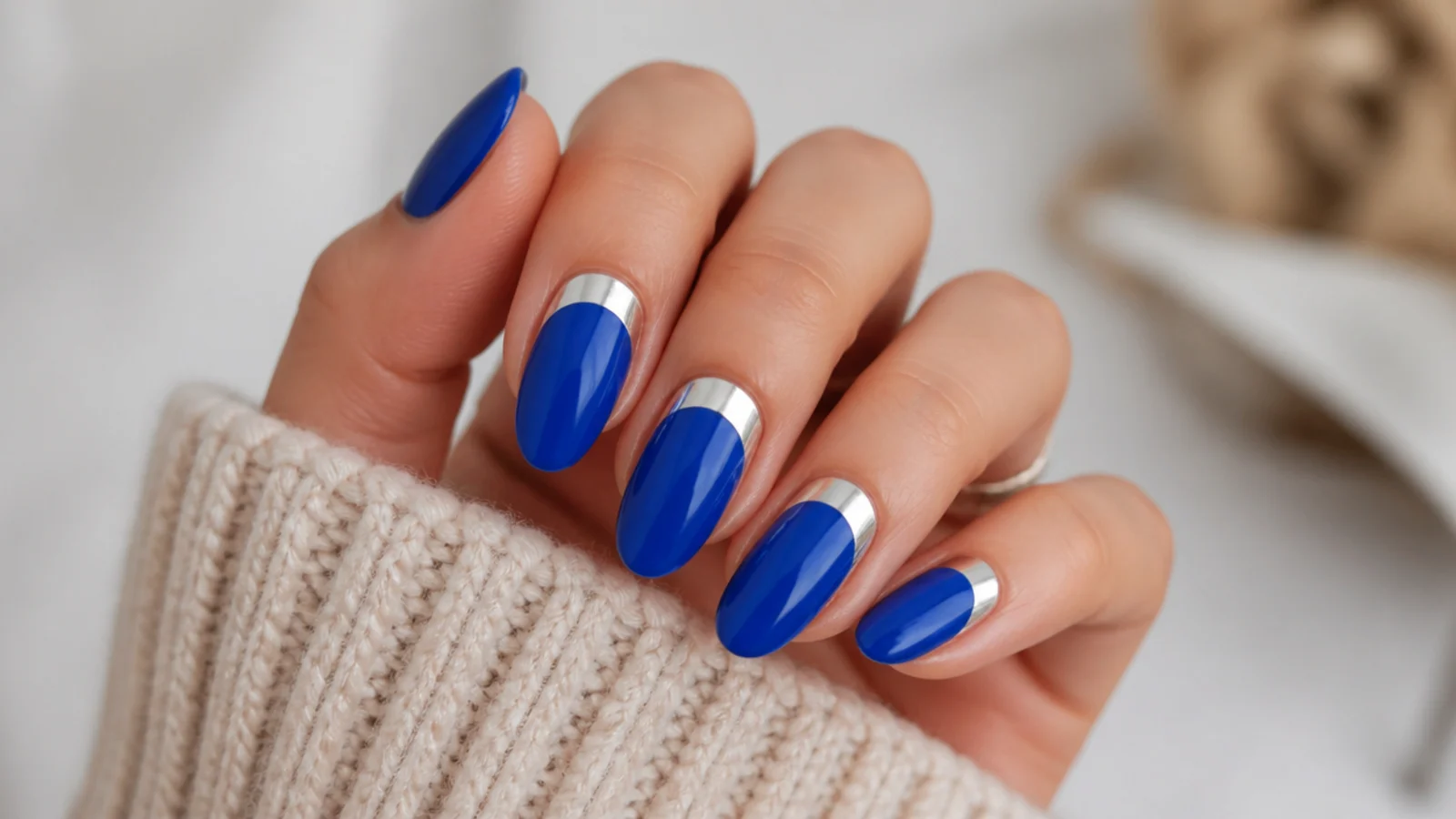 Royal blue almond nails with silver half-moons at the cuticle
