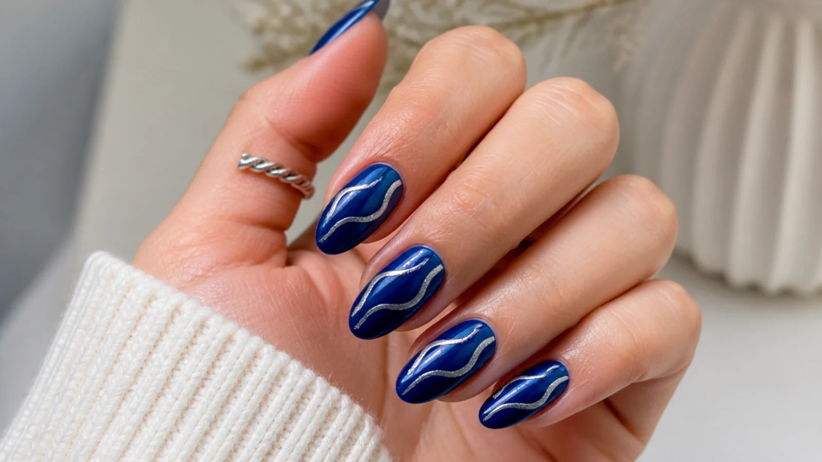 Royal blue nails with swirling silver wave lines across the surface