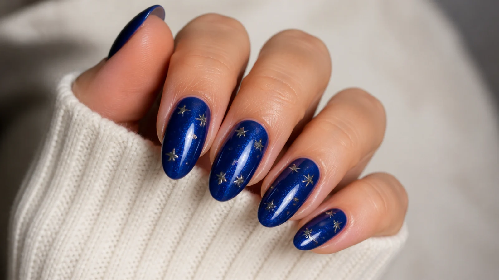 Deep royal blue nails with silver star studs and tiny glitter dots