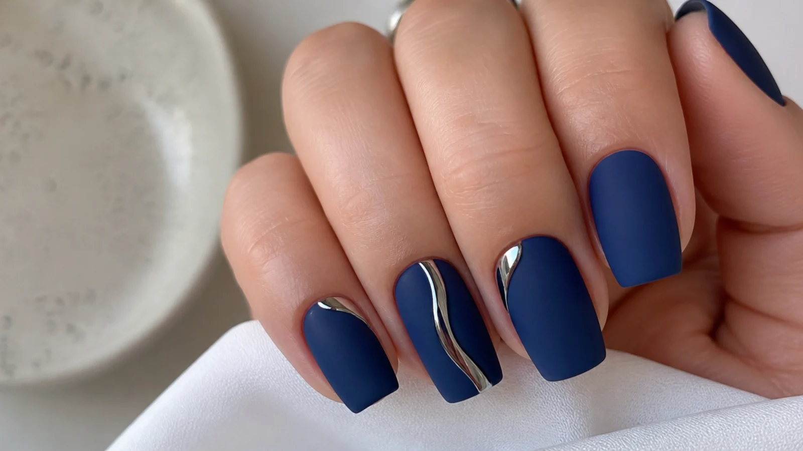 Matte royal blue nails with glossy silver chrome accent details