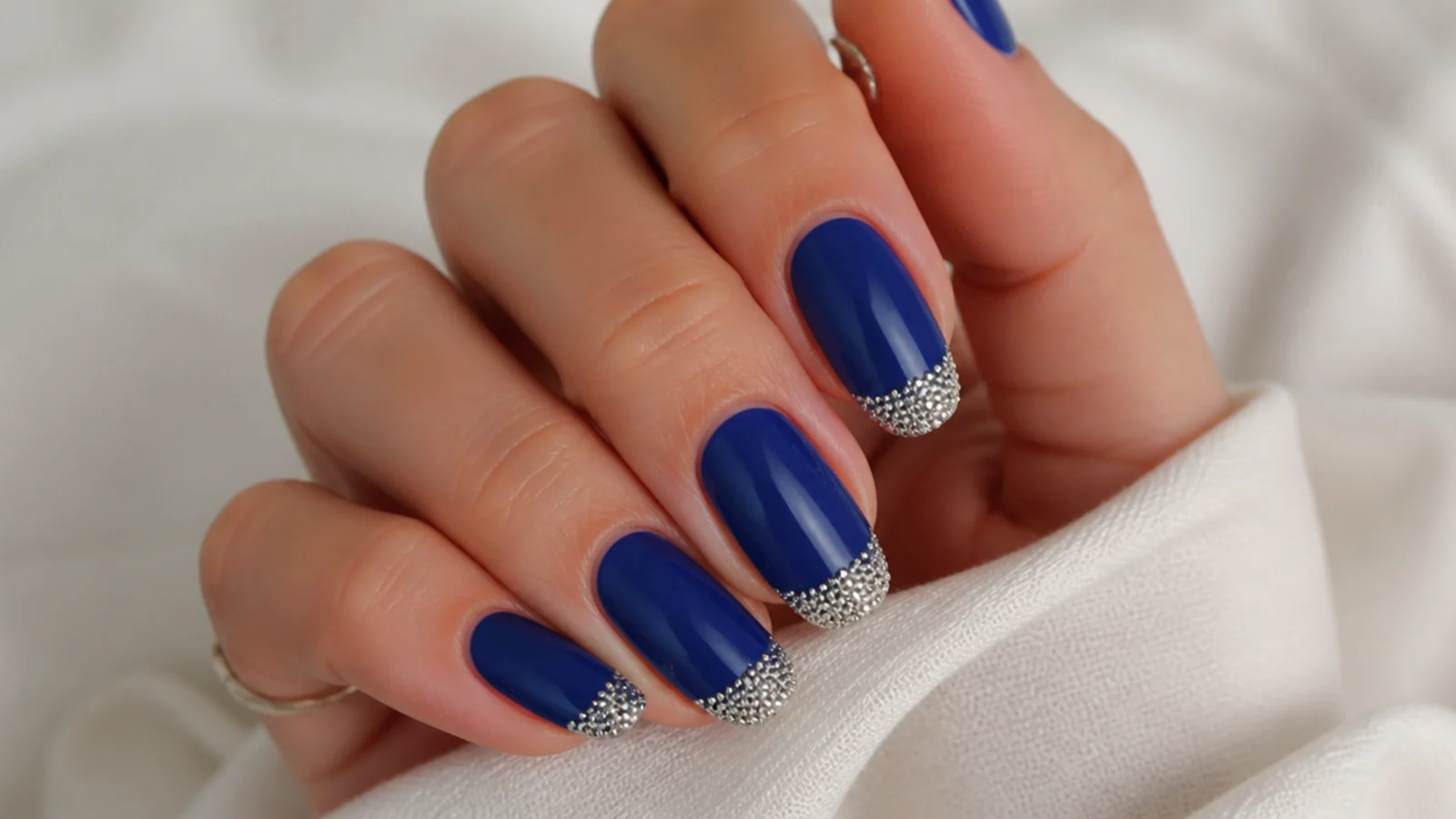 Royal blue nails with silver caviar micro-beads on the tips