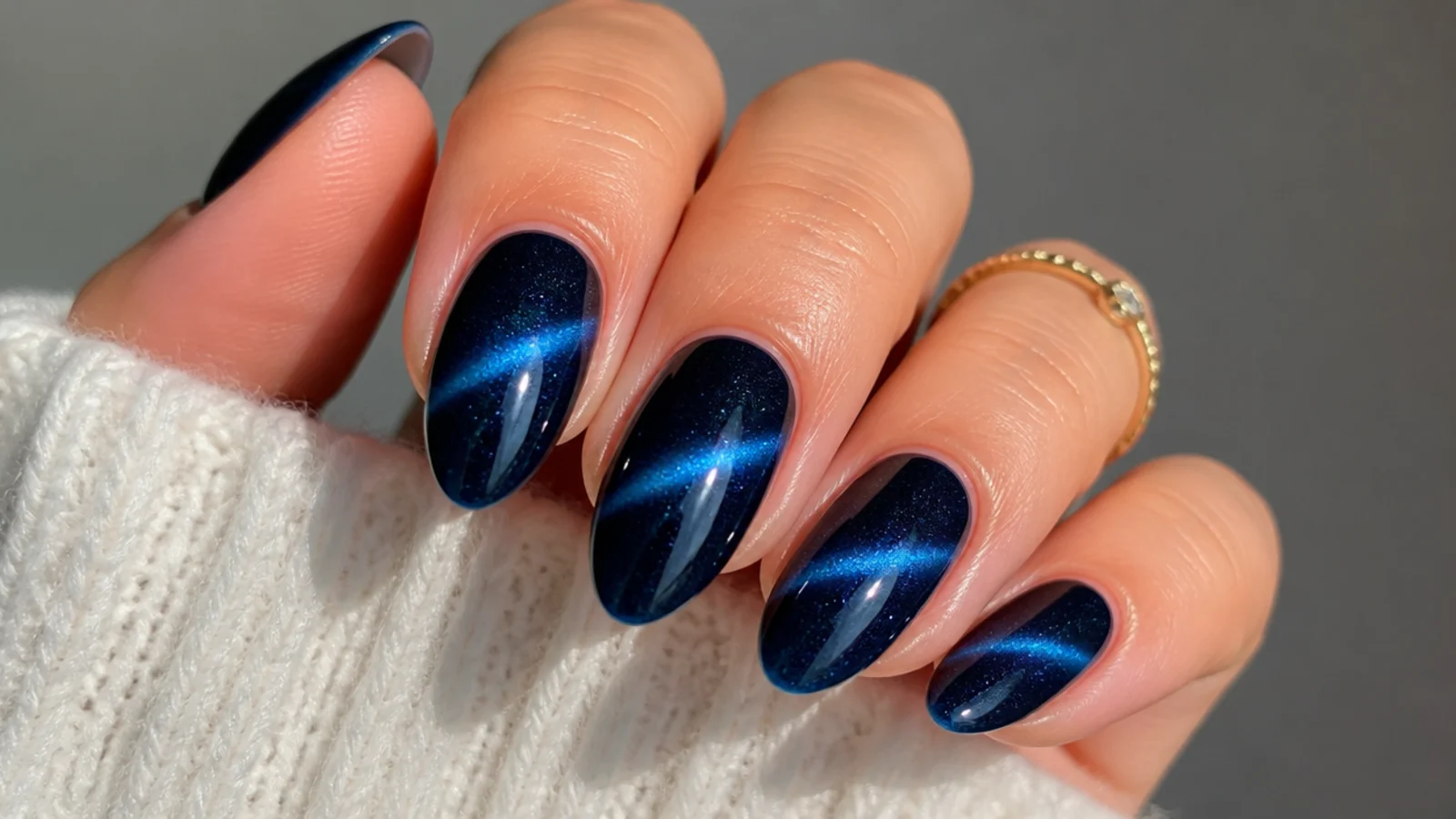 Royal blue cat eye nails with a slanted diagonal light streak across each nail
