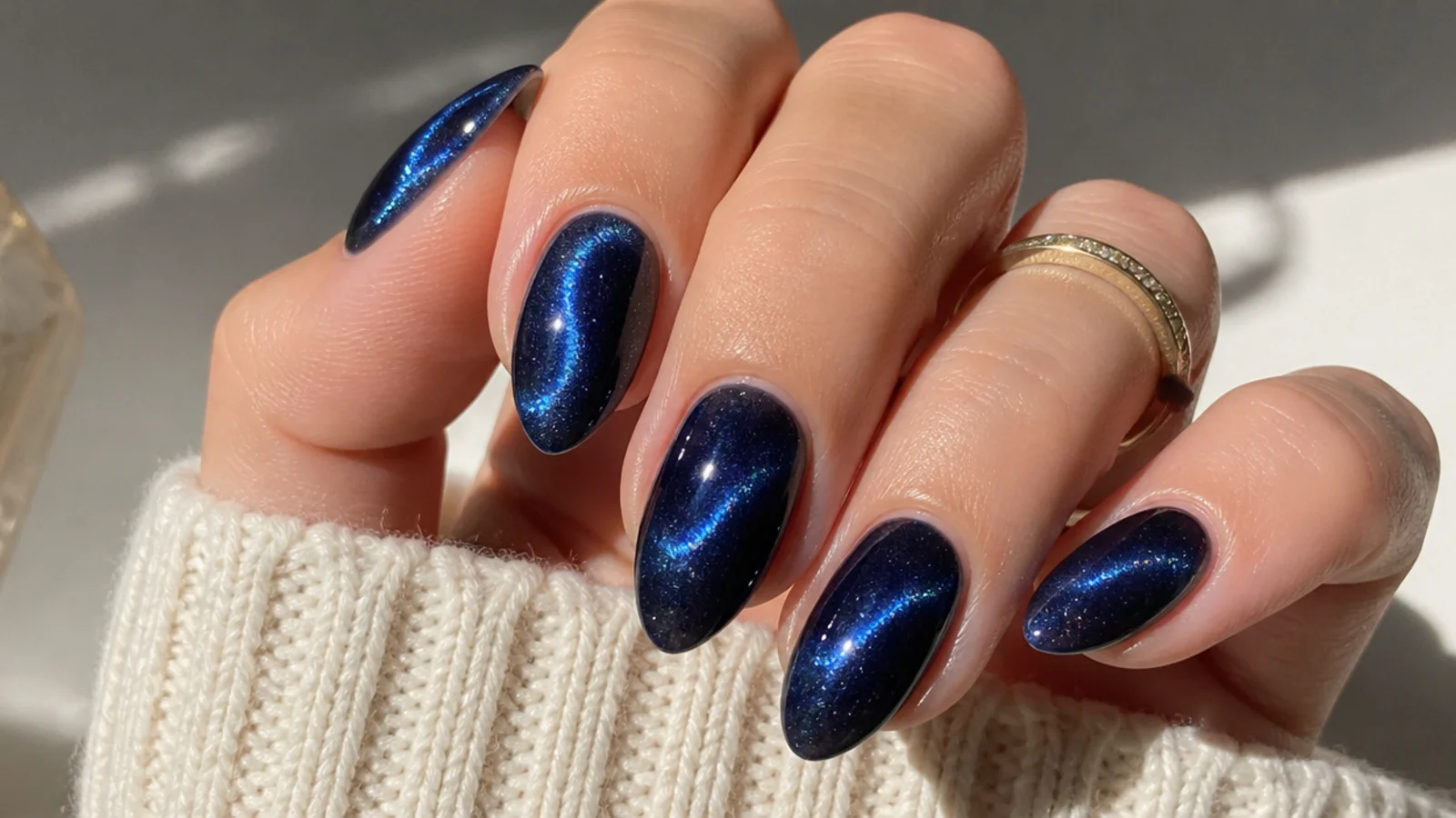 Deep royal blue cat eye nails with a swirled galaxy-like multidirectional light