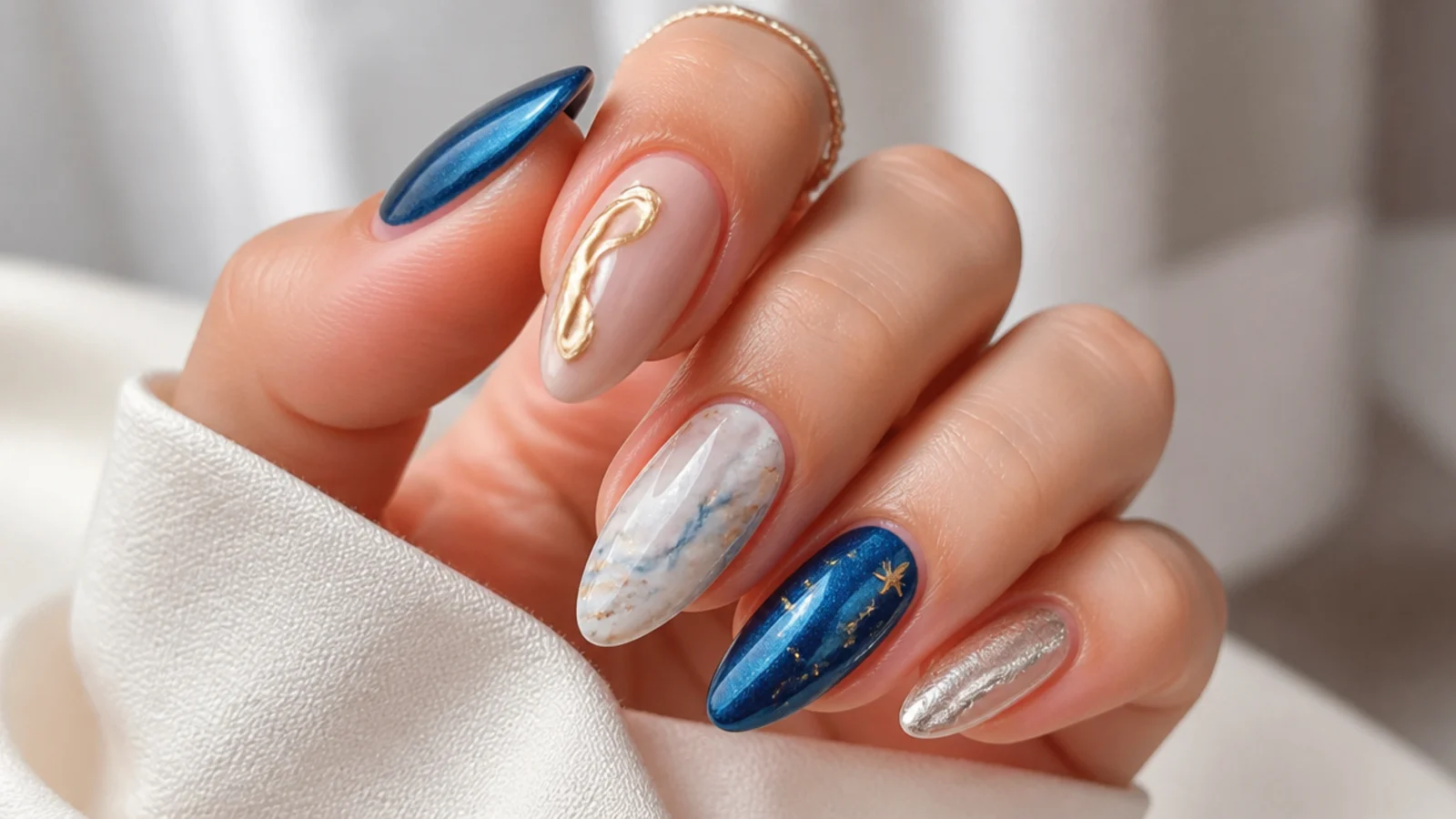 Royal blue cat eye nails paired with gold, silver, white and nude accent nails