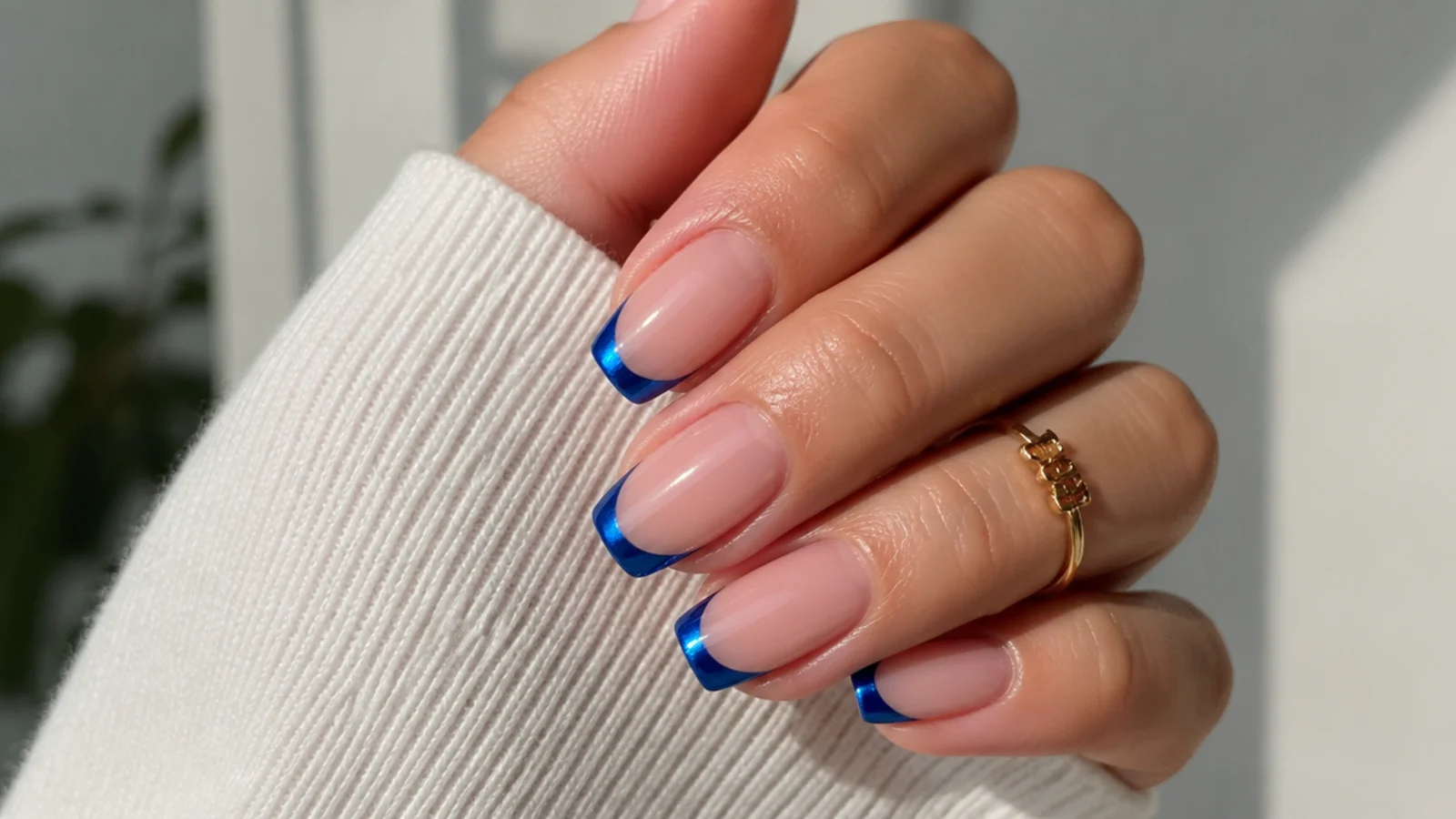 Nude nails with royal blue chrome french tips and a clean smile line