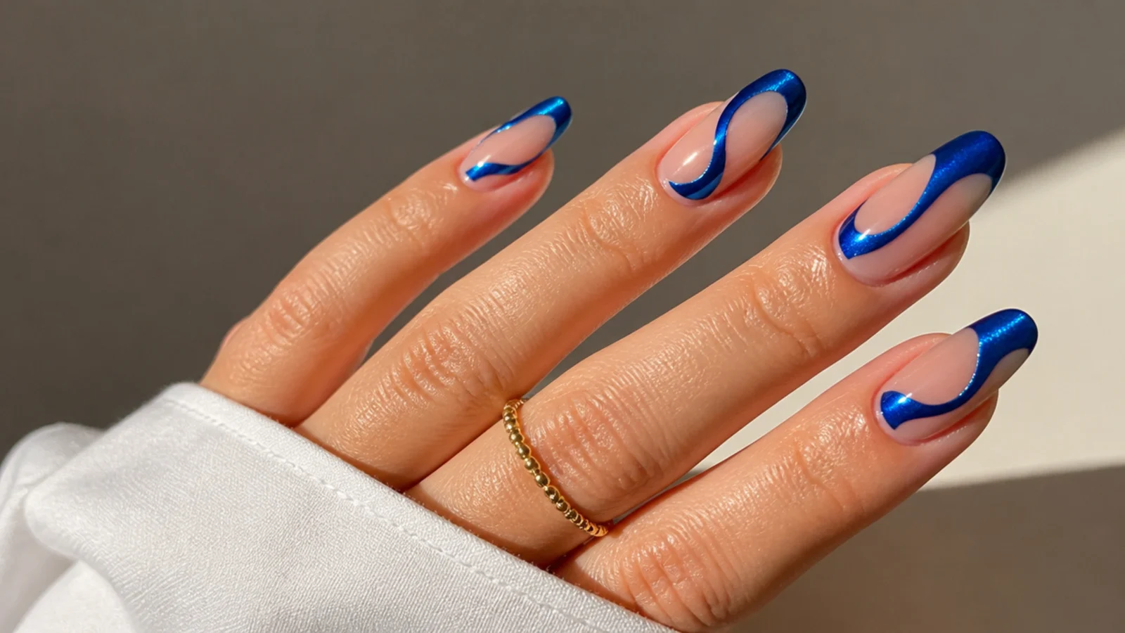 Clear nails with royal blue chrome shapes over negative space