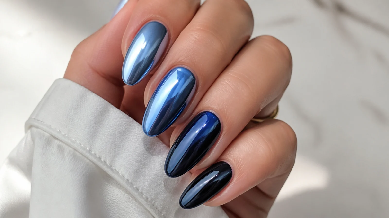 Chrome nails fading from light royal blue to deep navy across the set