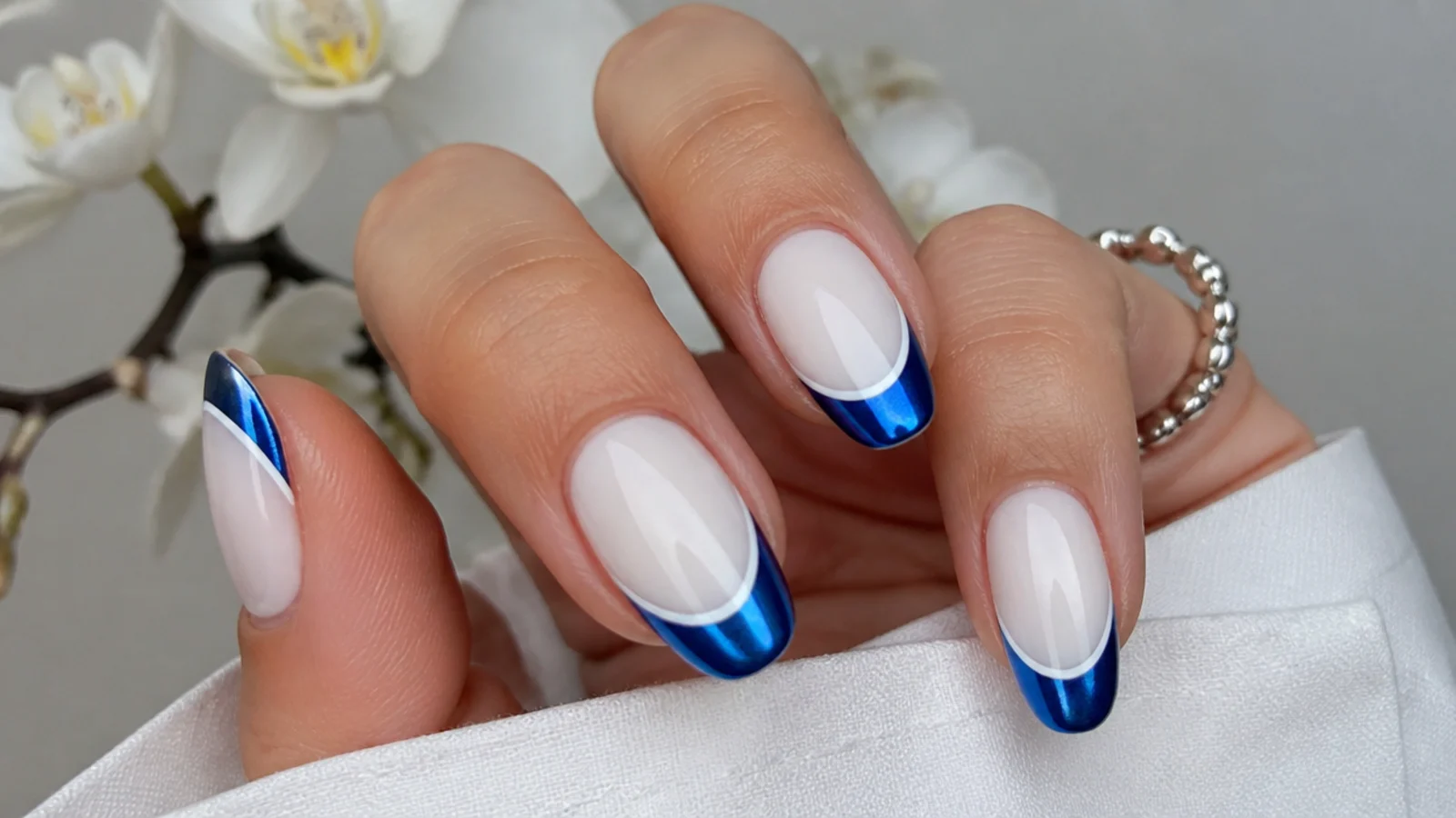 White nails with royal blue chrome french tips and thin white outline