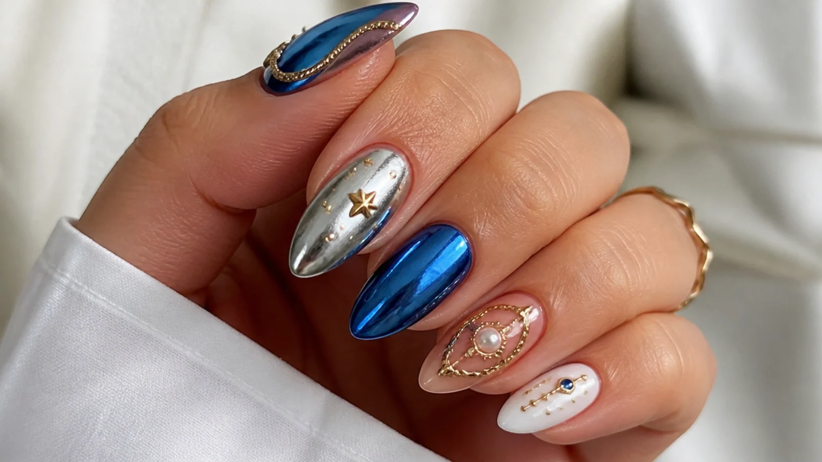 Royal blue chrome nails paired with gold, silver, white and nude accents