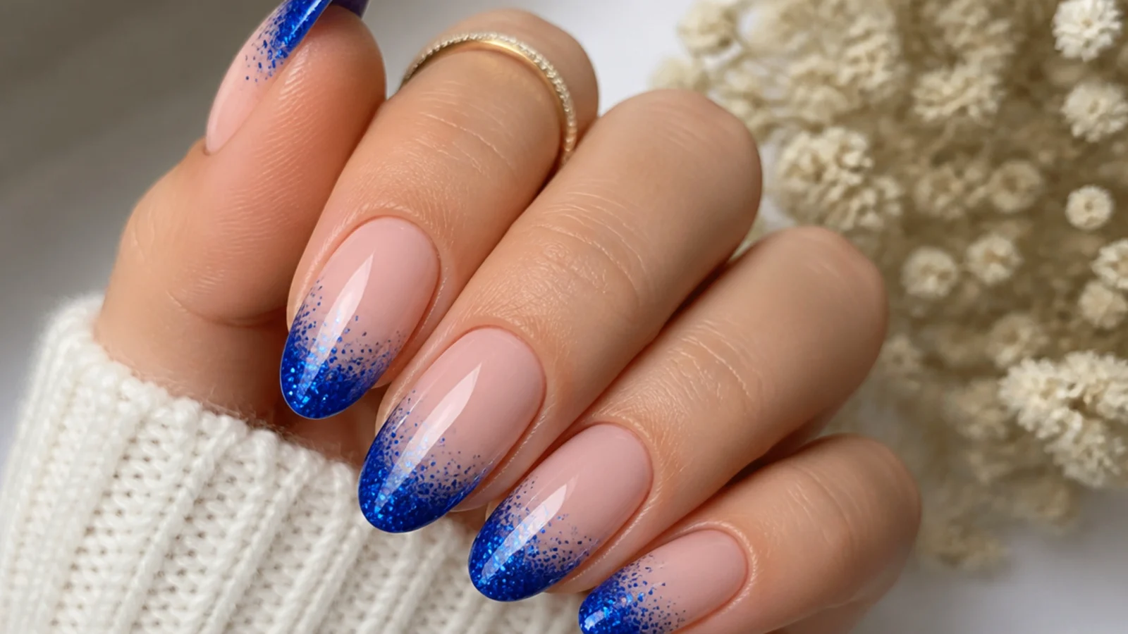 Royal blue french tips fading into blue glitter on a nude base