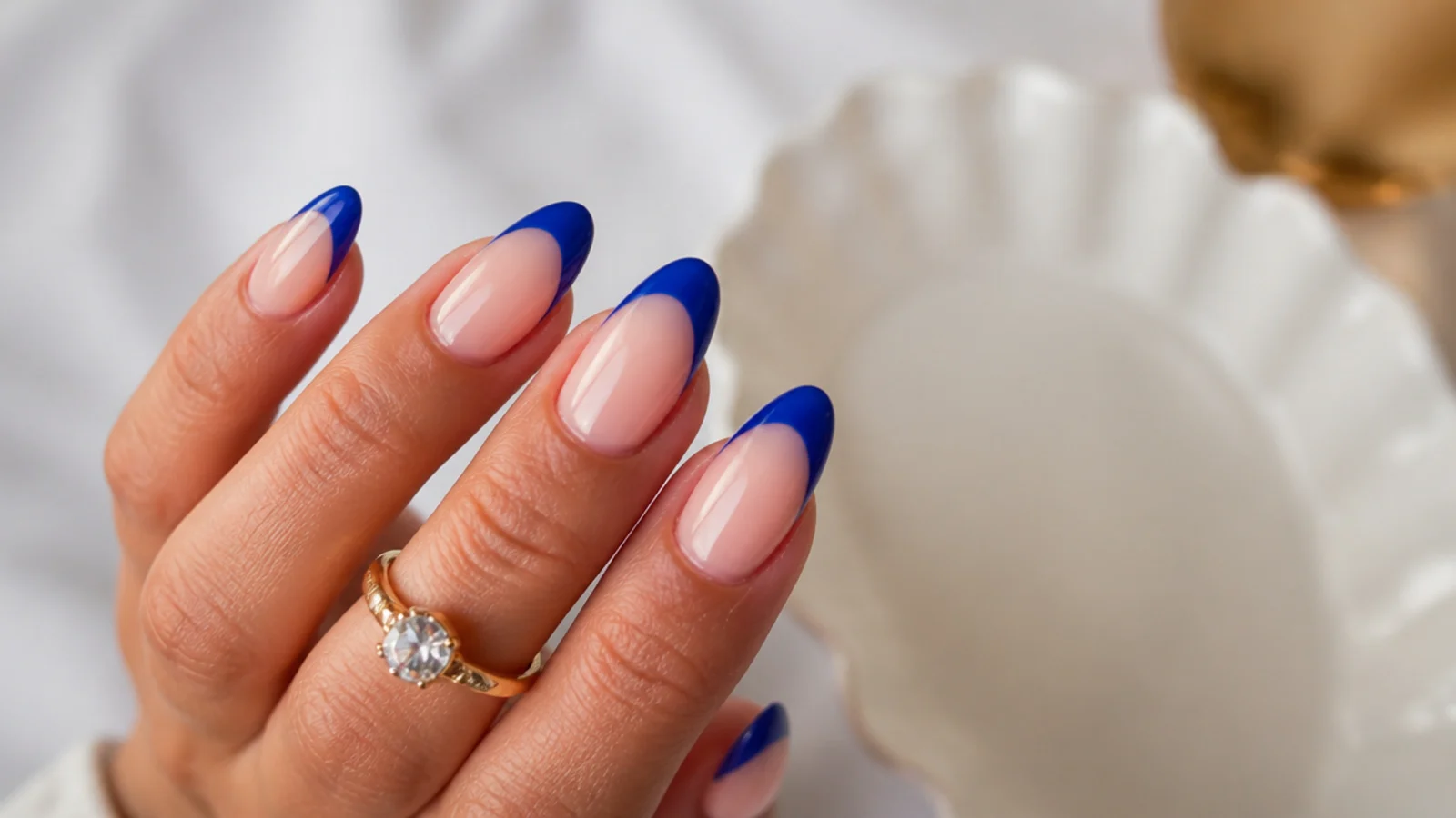 Royal blue french tips on long almond nails over a nude base