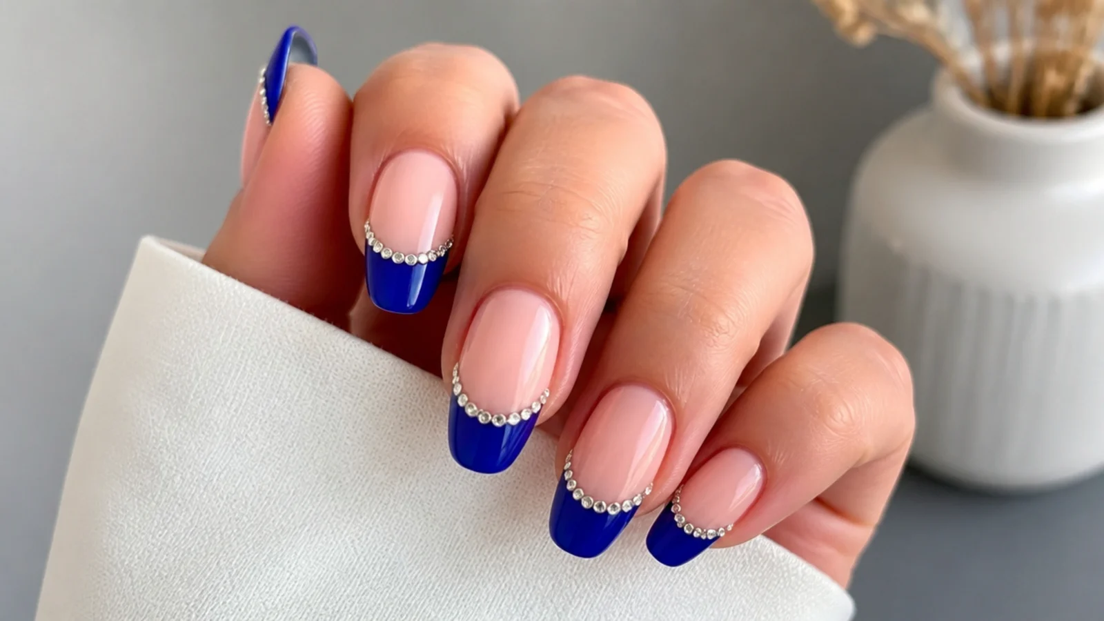 Royal blue french tips with clear rhinestones set along the smile line